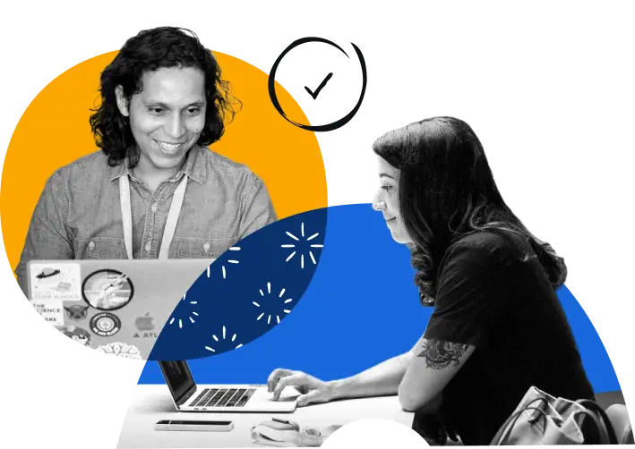 Two Atlassian employees working on their laptops.